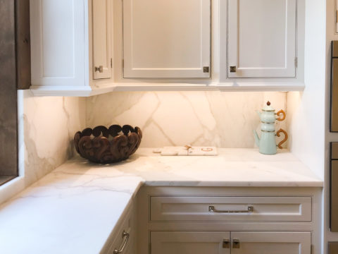 Calacatta marble backsplash in a white kitchen corner