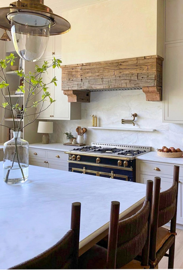 Kitchen with reclaimed wood hood and marble backsplash