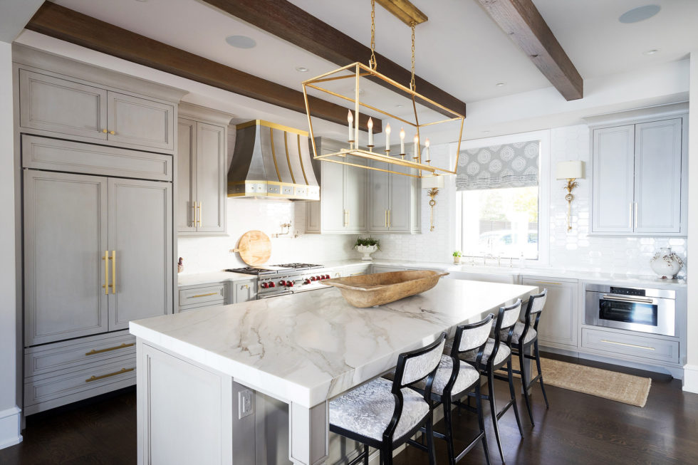 Kitchen with gold pendants and marble counters
