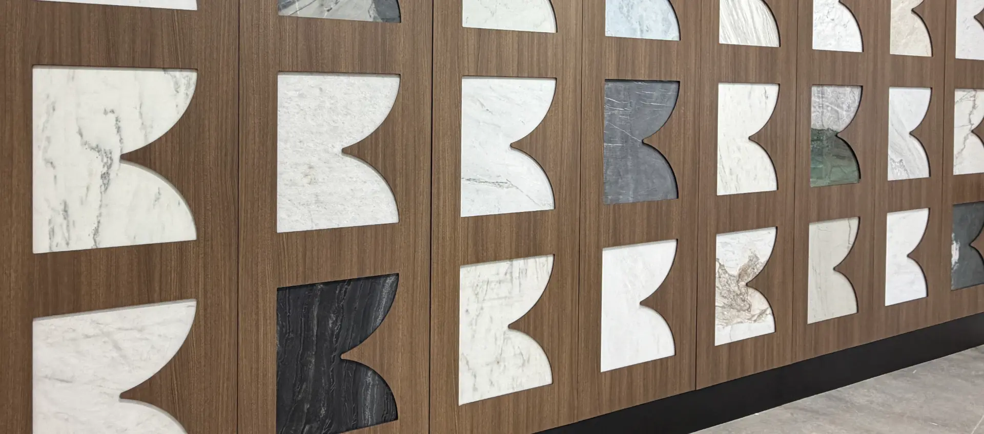 Walnut feature wall inset with marble and quartzite samples cut in the Bottega B shape