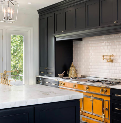 Navy kitchen with brass range and marble counters