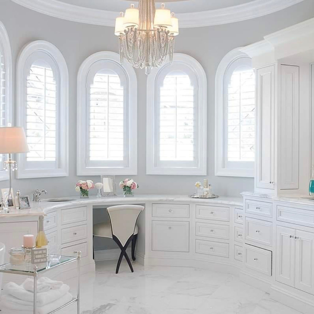 Marble bath with arched windows and a chandelier