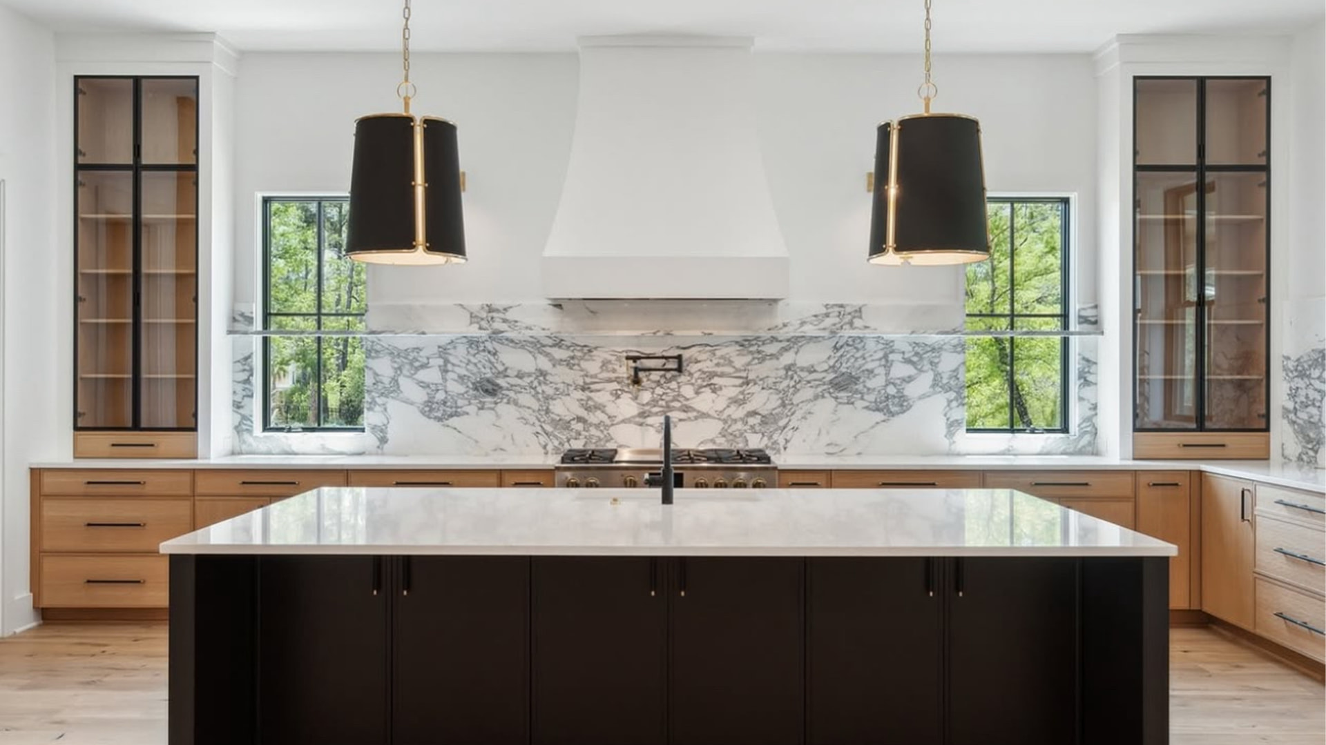 Luxury kitchen with heavily veined marble backsplash and a white marble island