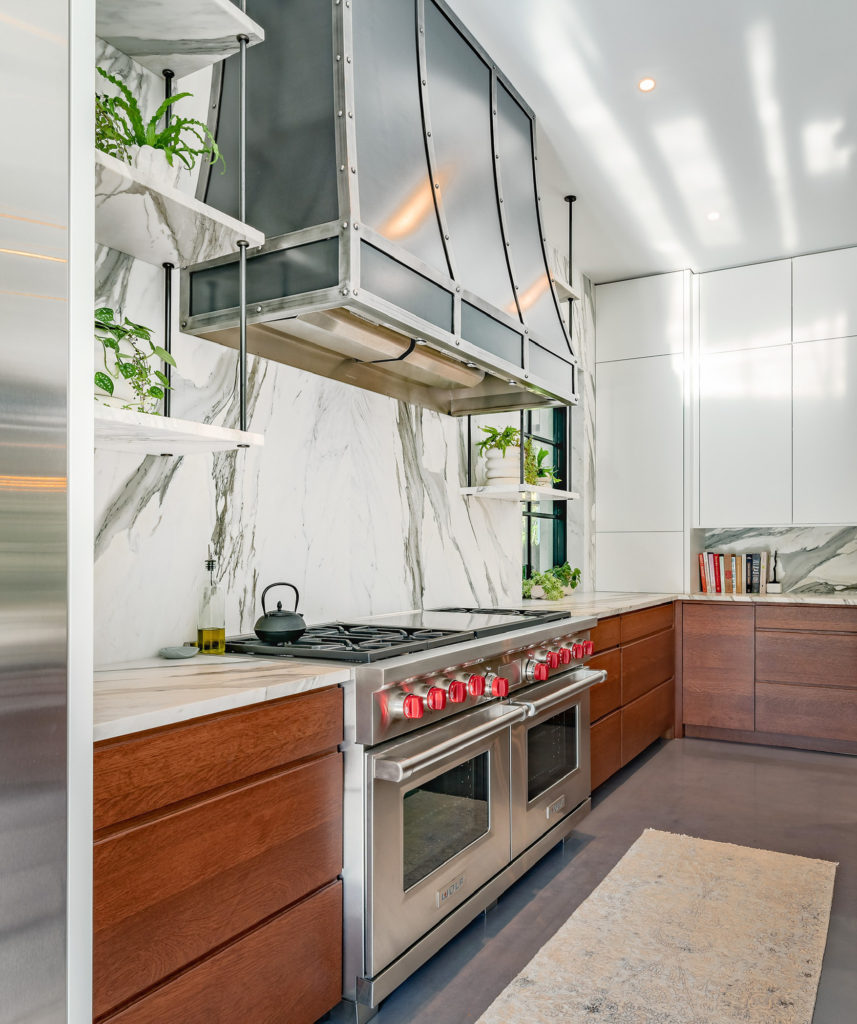 Marble kitchen with walnut cabinets and glass shelving