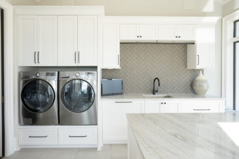 Laundry room with a marble counter and herringbone tile