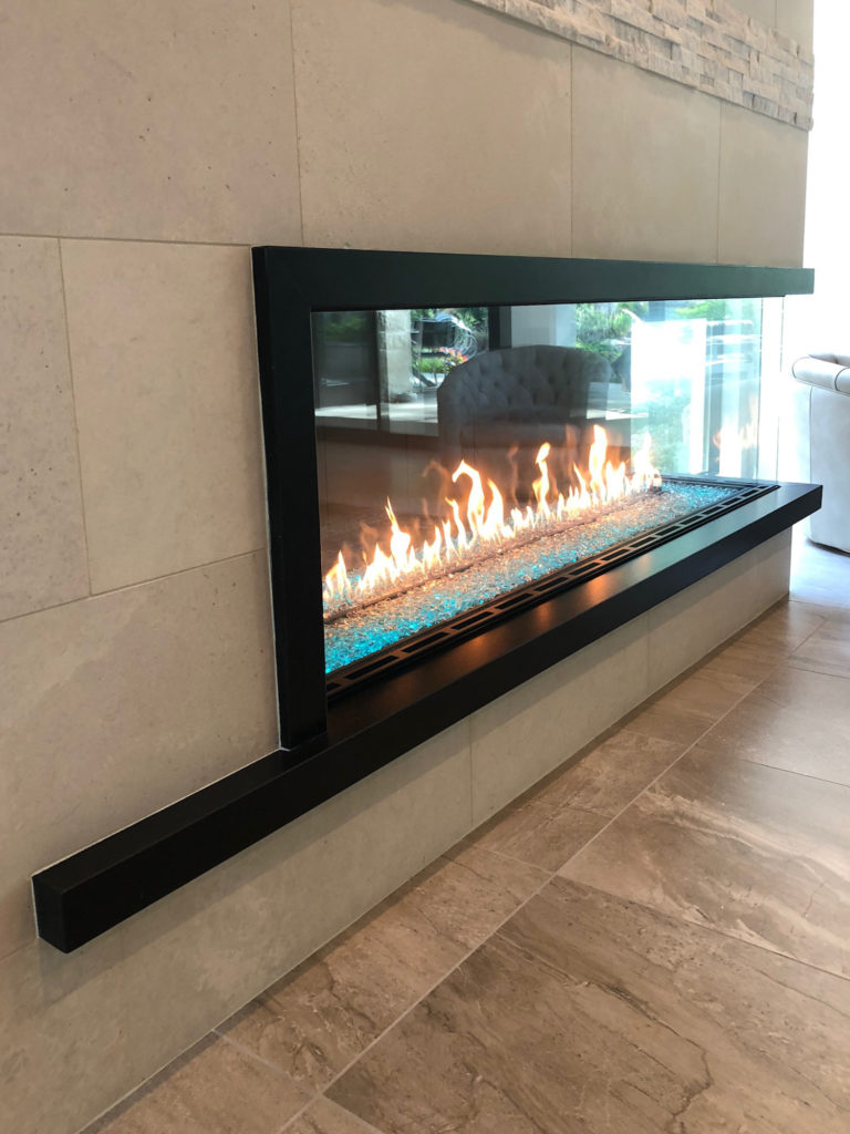 Linear gas fireplace with a stone surround