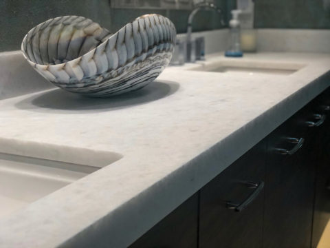 Honed marble countertop with a sculptural stone bowl