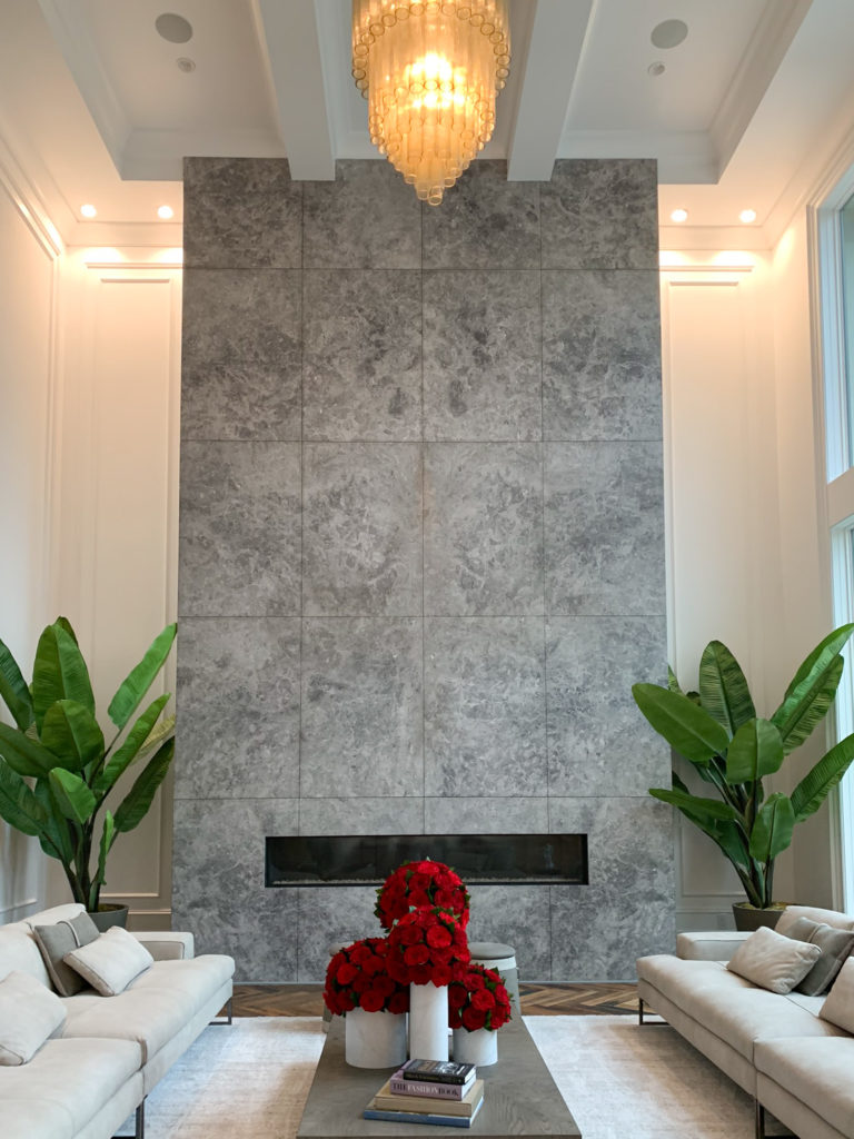 Two-story marble fireplace wall with chandelier