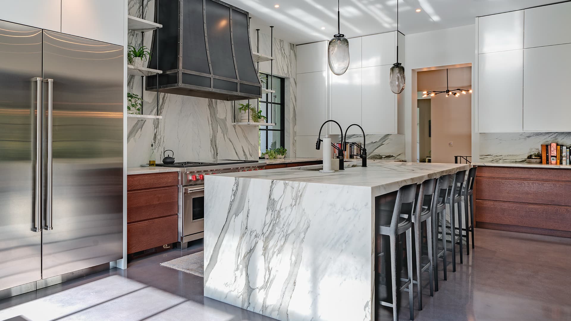 Marble waterfall kitchen island with dark stools in an Atlanta home
